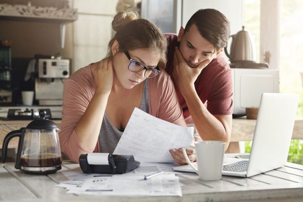 young-caucasian-family-having-debt-problems-able-pay-out-their-loan-female-glasses-brunette-man-studying-paper-form-bank-while-managing-domestic-budget-together-kitchen-interior